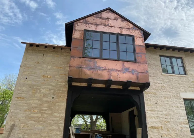 Copper metal panel facade on a stone building for Skylight Installation in Zion